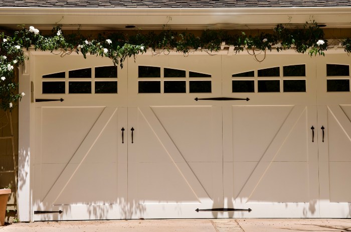 White carriage-style garage doors with decorative hardware at a home in Jacksonville, FL
