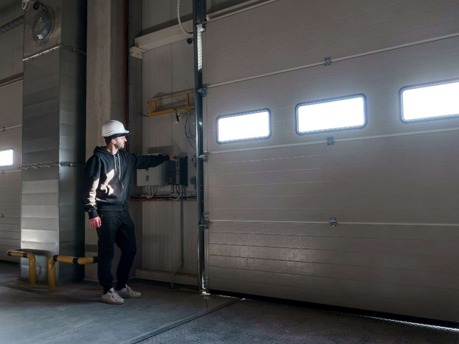 A man is checking the garage door after installing it in a commercial area in Jacksonville, FL