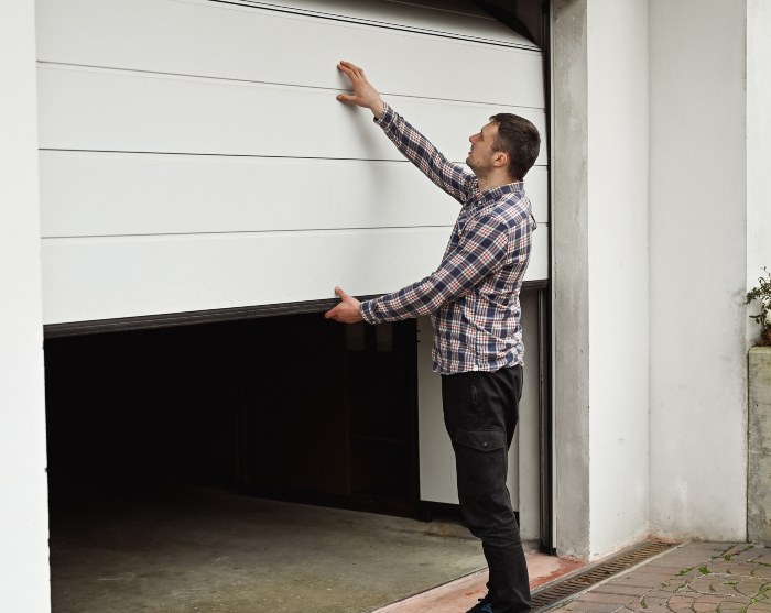 A professional is closing the garage door after repairing it in Jacksonville, FL.