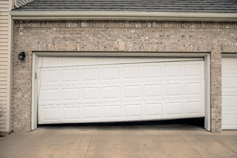 Damaged garage door panel bent out of shape on residential home in Jacksonville, FL