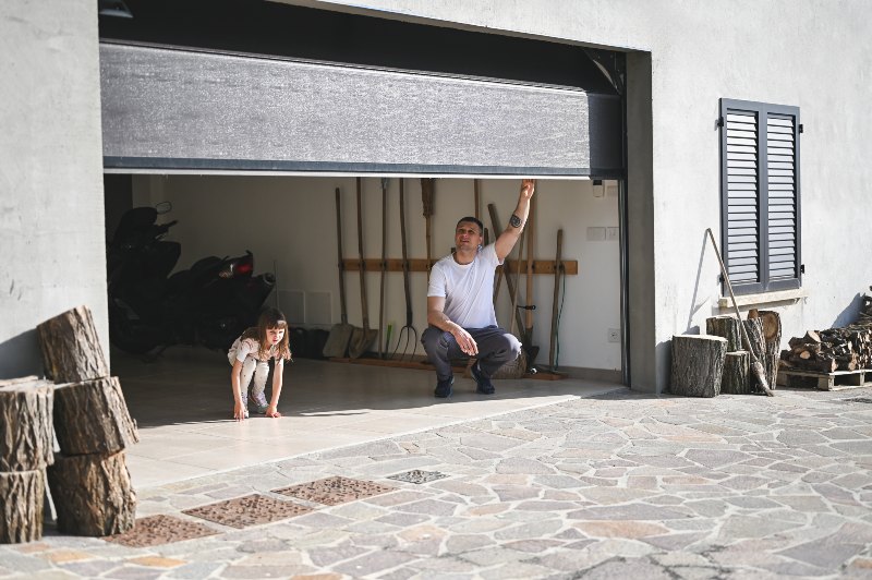 Father and child opening garage door together at home in Jacksonville, FL