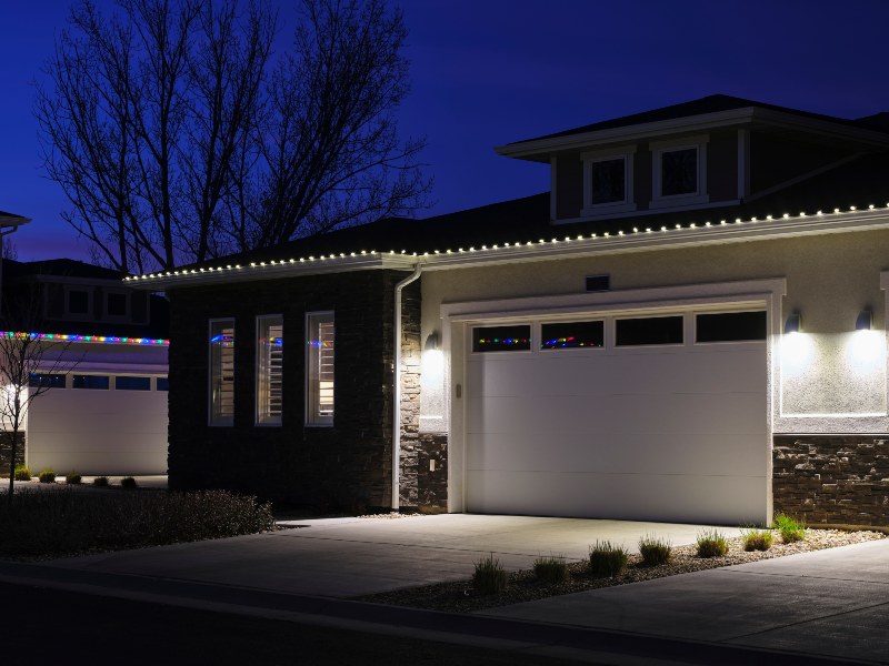 Modern home with illuminated garage door and exterior lighting at night in Jacksonville, FL