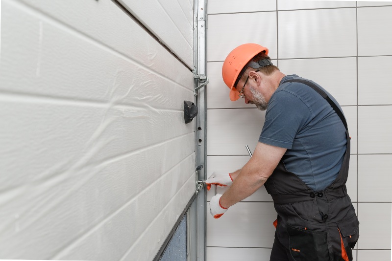 Garage door technician adjusting side track hardware and alignment in Jacksonville, FL